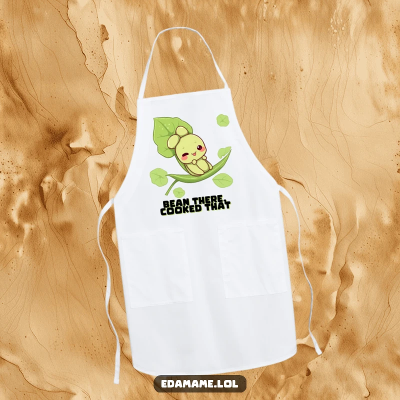 Funny apron designed with a cute edamame character enjoying a leaf slide, adding humor to kitchen duties.